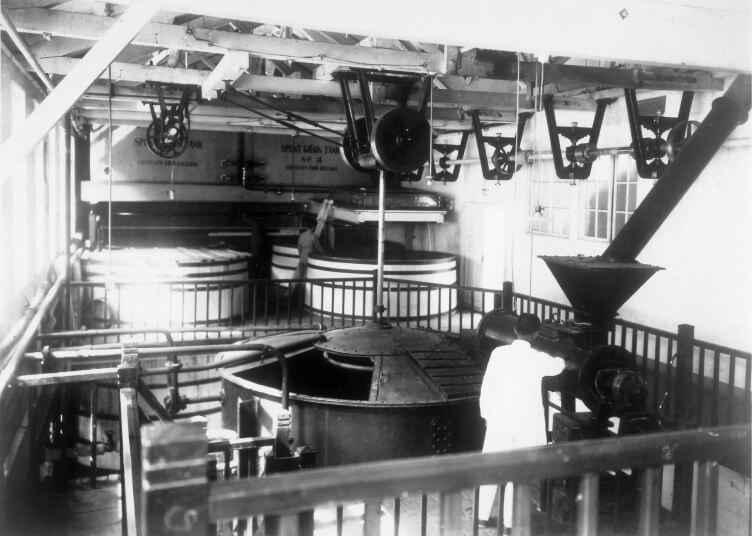 Historic black-and-white photo of the manufacturing floor at Suntory’s Yamazaki Distillery