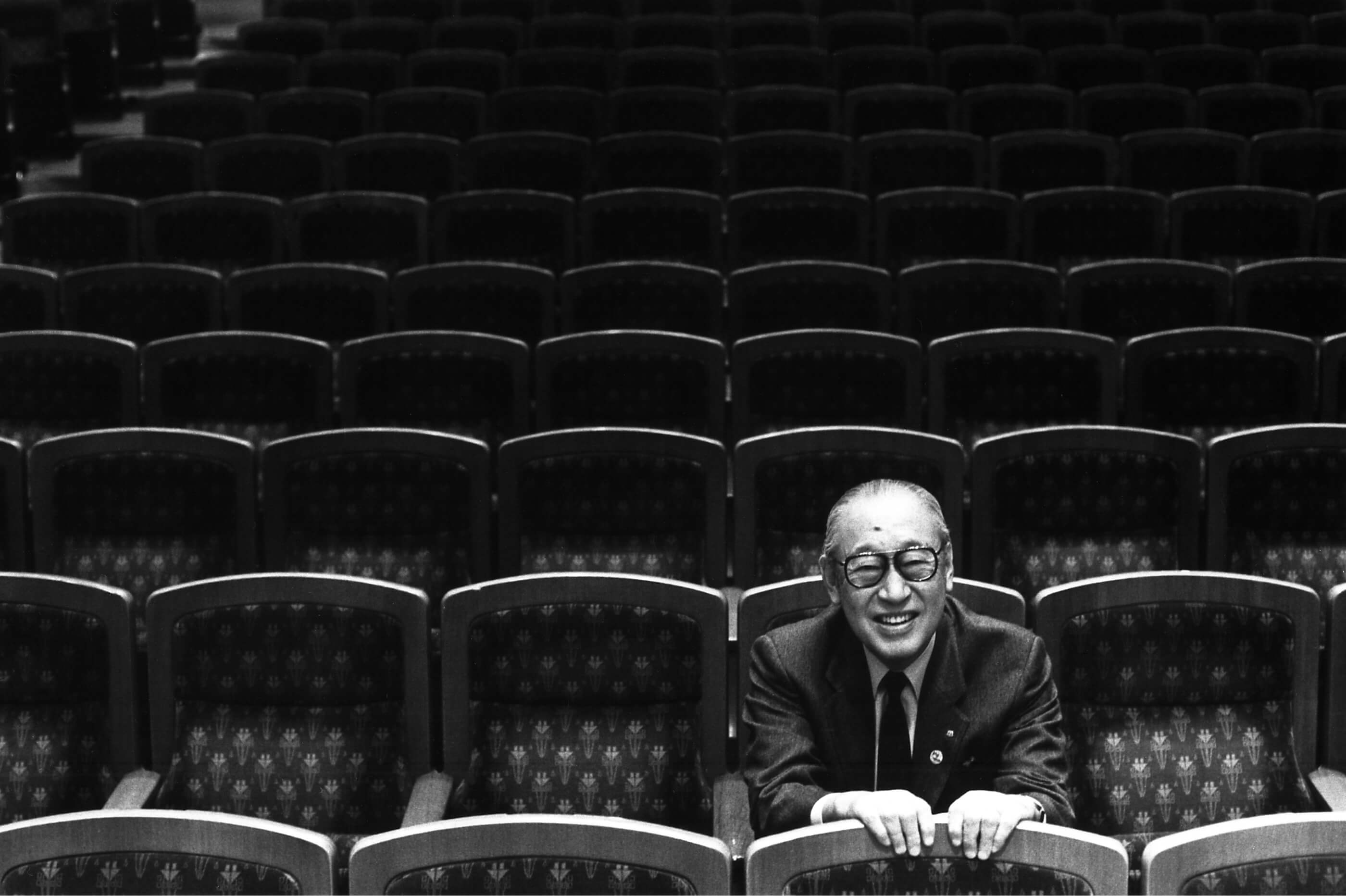 Black-and-white photo of former Suntory president Keizo Saji seated alone in the Suntory Music Hall