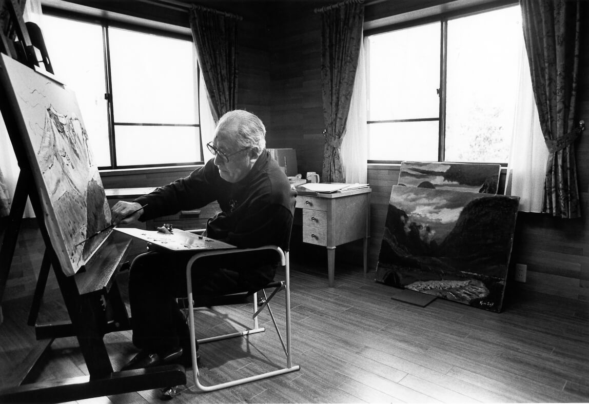 Black-and-white photo of former Suntory president Keizo Saji painting a canvas