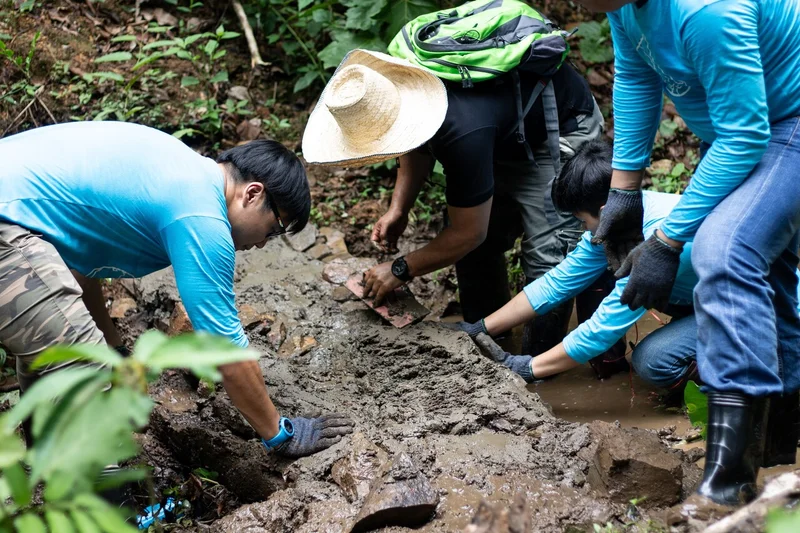 Creating a check dam to block mud from flowing into the Ping River in northern Thailand. Other watershed conservation activities include slowing the flow of streams to prevent soil erosion and tree-planting to prevent soil from flowing into streams.